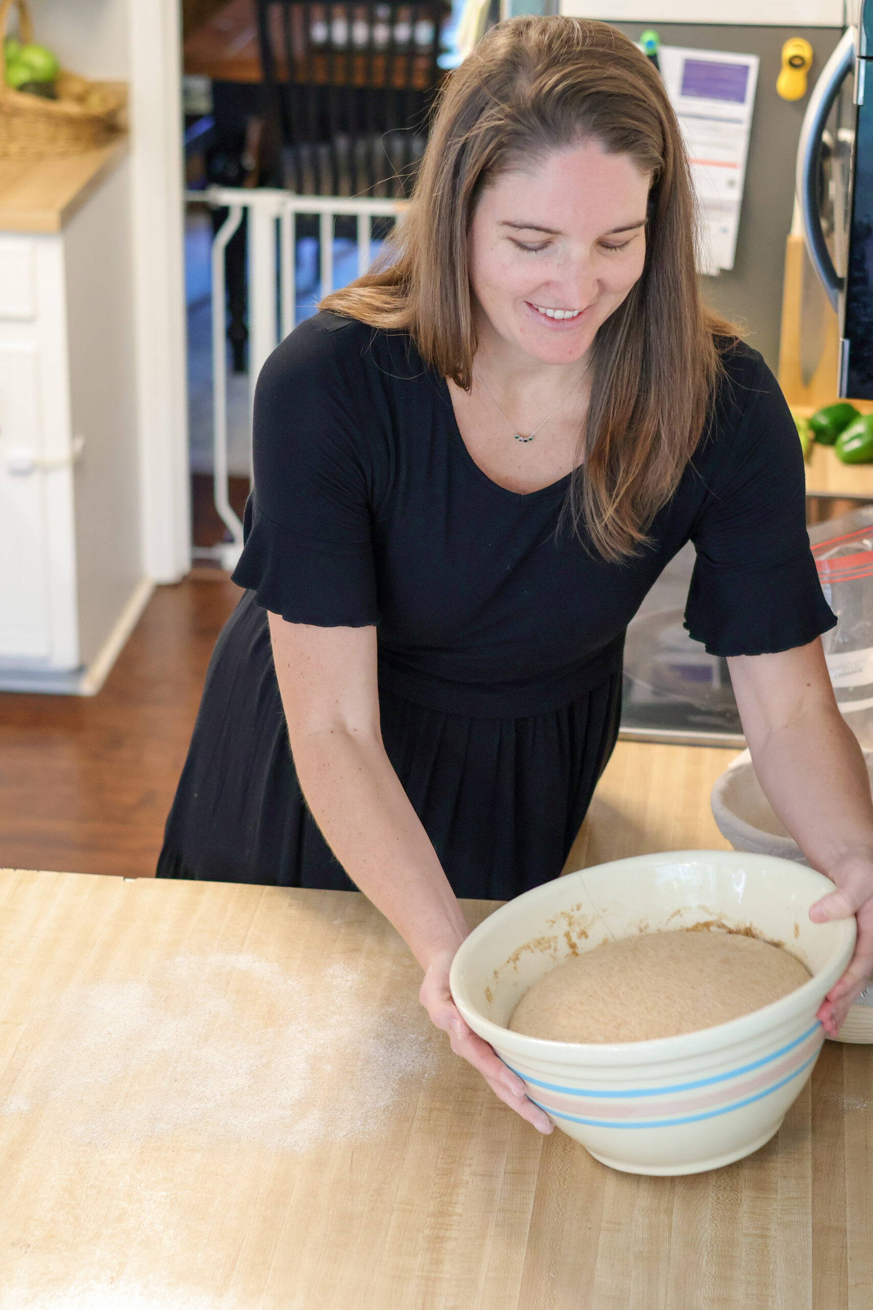 Woman holding bowl of sourdough bread