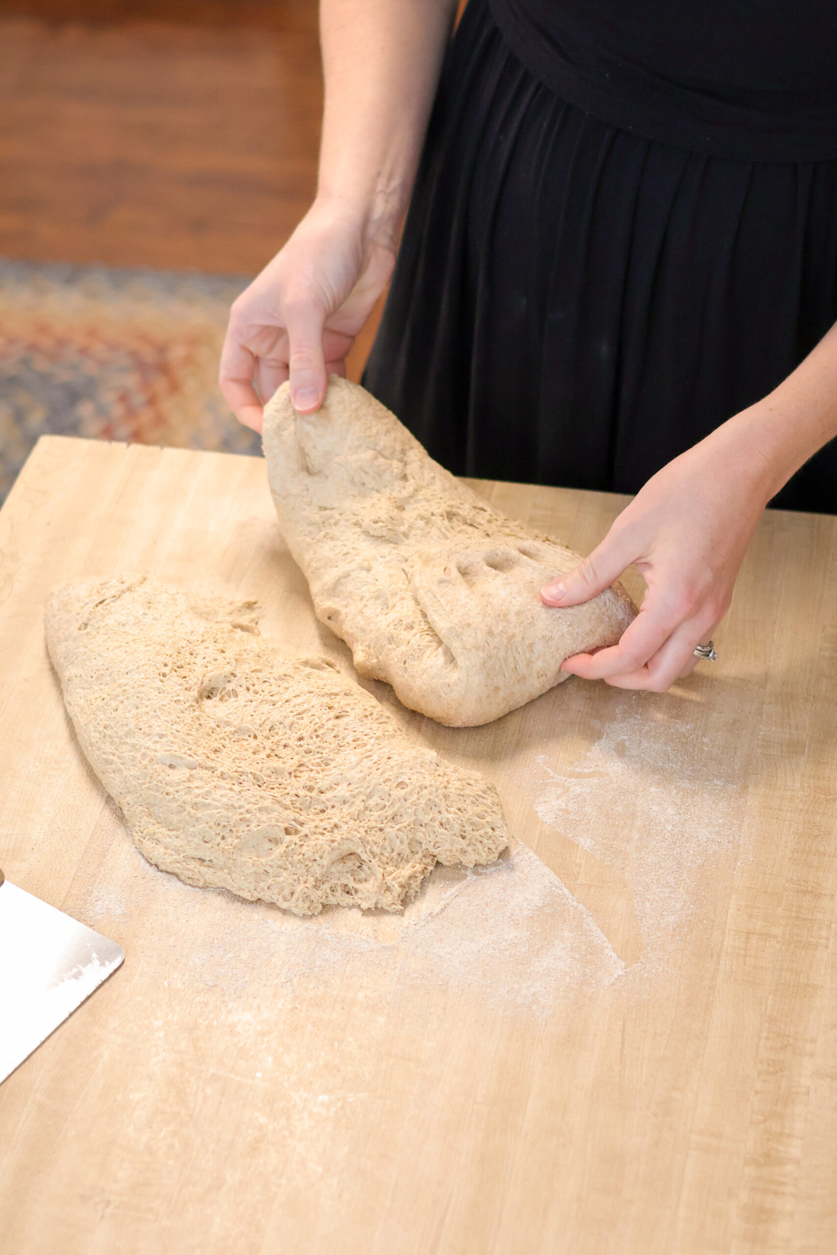 Pulling edges of dough together to form a loaf of bread