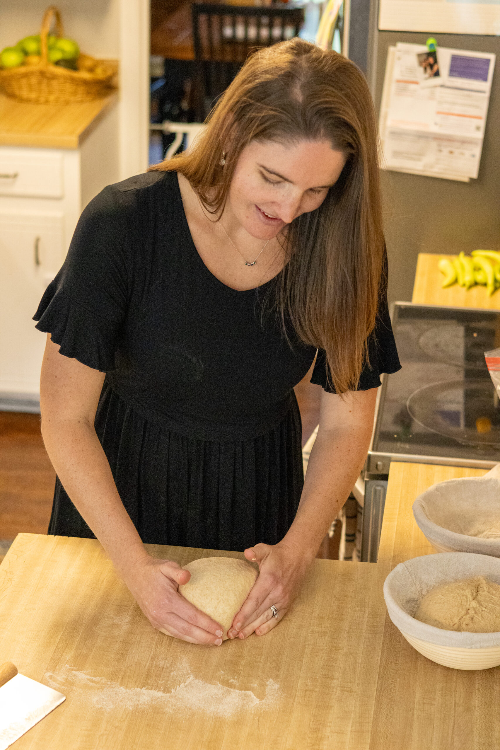Woman shaping sourdough bread on the counter top
