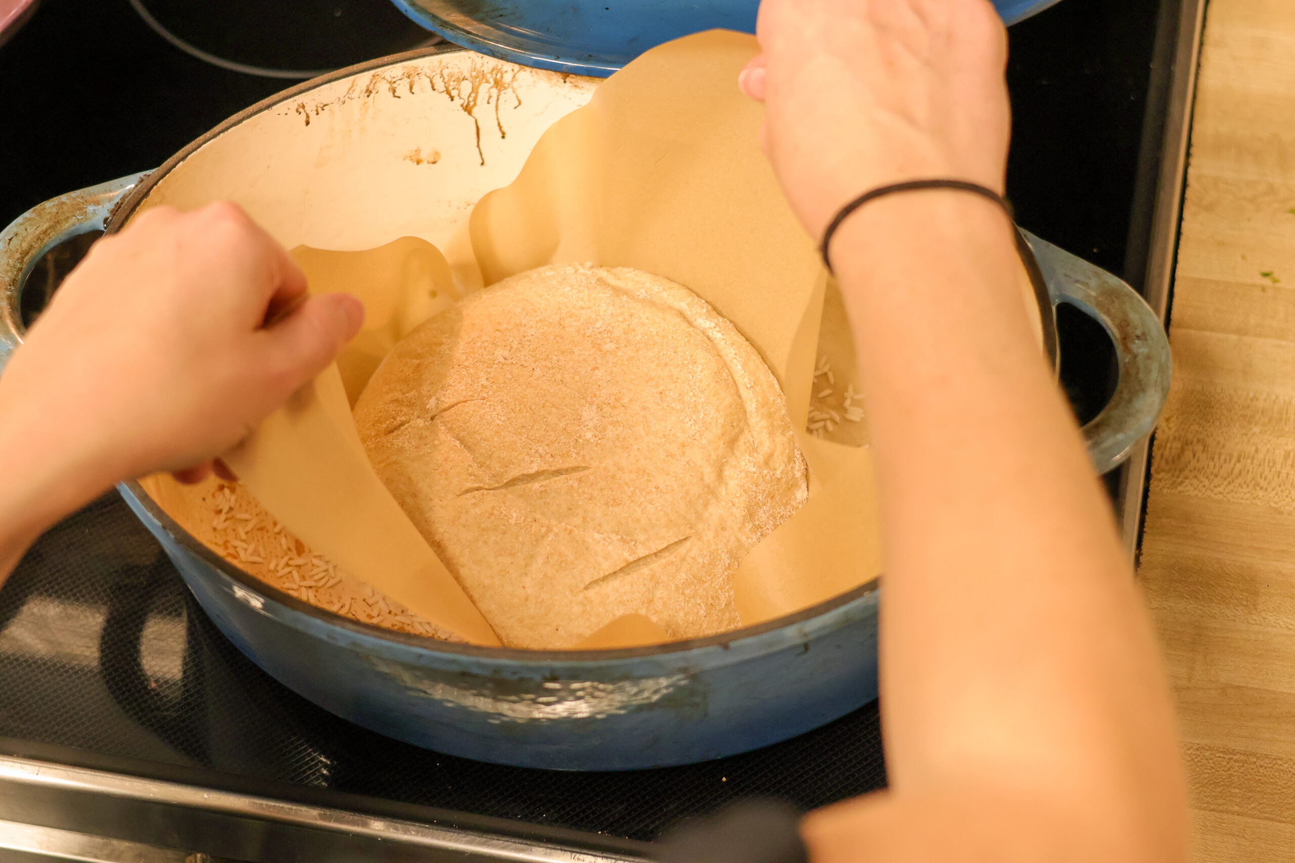 Putting sourdough loaf into preheated dutch oven for baking